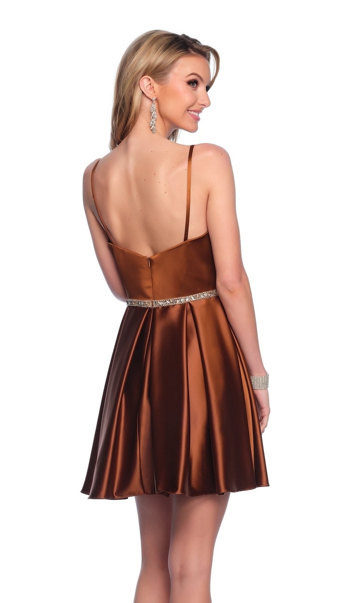 A woman poses with her back to the camera in the Bronze Brown Homecoming Dress 12066, featuring a sleeveless design, jeweled waistband, and lustrous satin fabric that shimmers beautifully against a white backdrop.